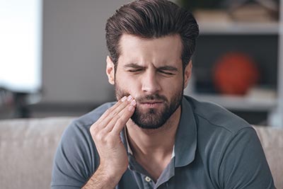 man in tooth pain in need of an emergency dentist in Denver, CO